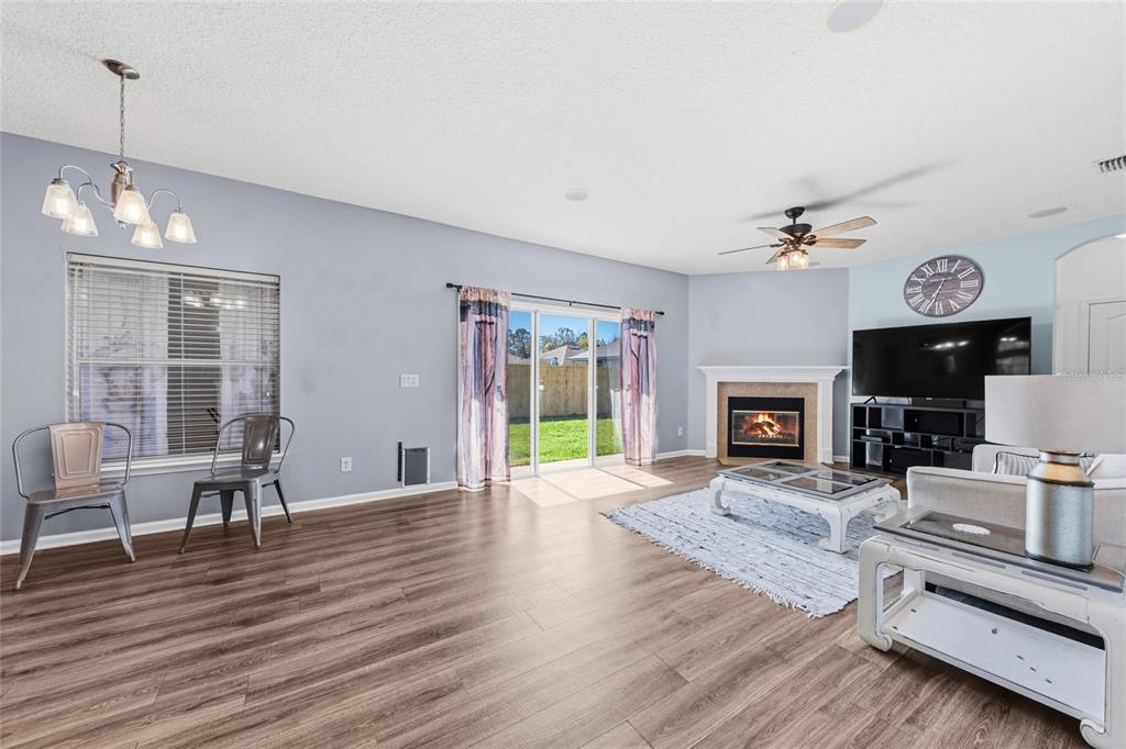 45095 Dutton Way Callahan, FL 32011 - Photo 21 of 36 a living room with furniture a fireplace and a flat screen tv