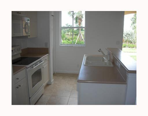 2928 Hidden Hills Road, Unit 1403 West Palm Beach, FL 33411 - Photo 10 of 13 a kitchen with windows and cabinets