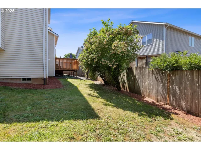 a view of a backyard with potted plants and a wooden fence