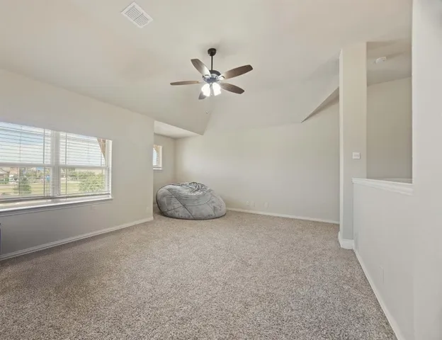 a view of a livingroom with a ceiling fan and window