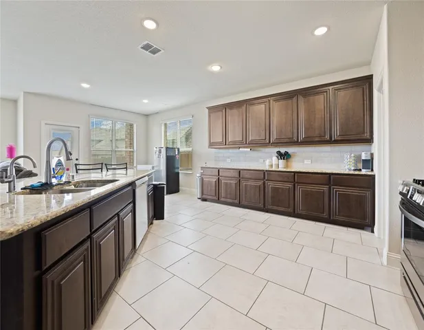 a kitchen with stainless steel appliances a sink dishwasher stove top oven and cabinets