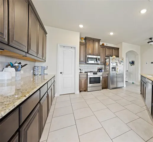 a kitchen with stainless steel appliances granite countertop a refrigerator and a sink