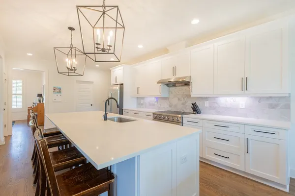 a kitchen with kitchen island white cabinets and appliances