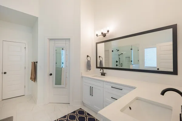 a bathroom with a sink vanity granite shower and a mirror