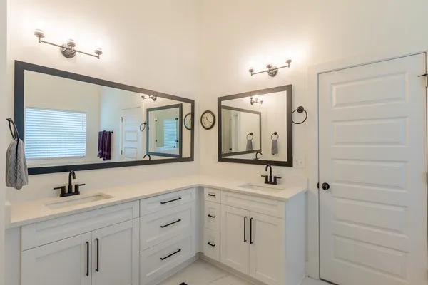 a bathroom with a double vanity sink mirror and