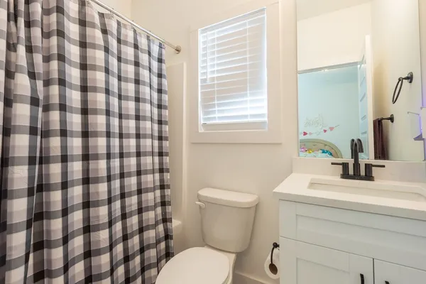 a bathroom with a sink toilet vanity and shower