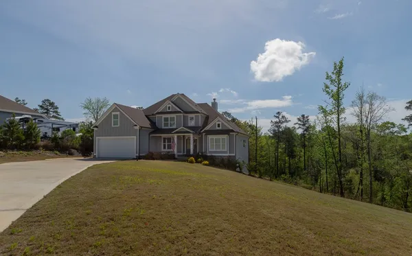 a front view of a house with a yard and garden
