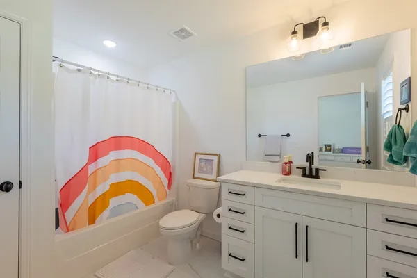 a bathroom with a sink a toilet and a mirror