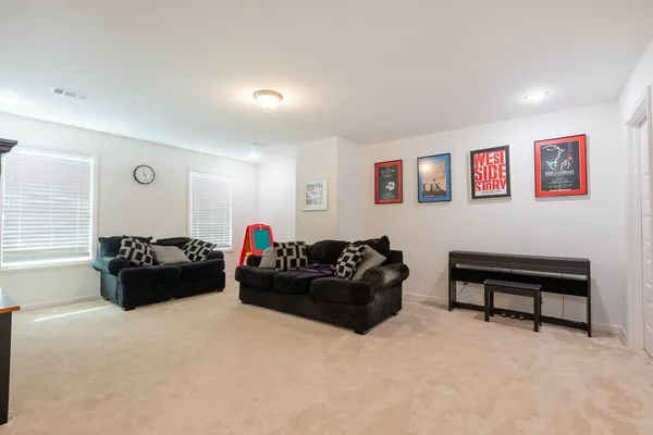 a living room with furniture and a piano