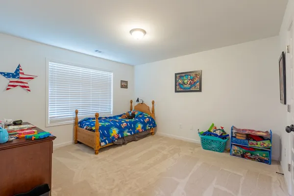 a living room with furniture and a baby crib