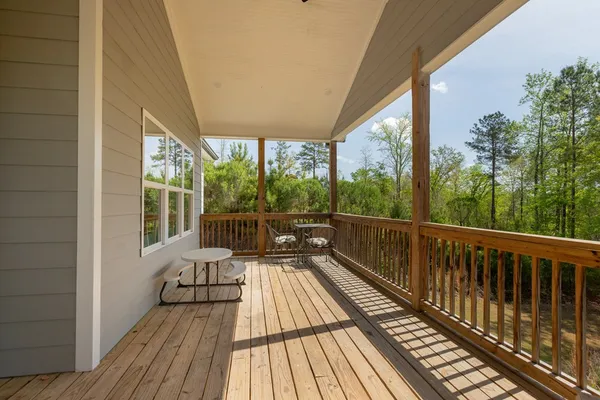 a view of a balcony with wooden floor and outdoor seating