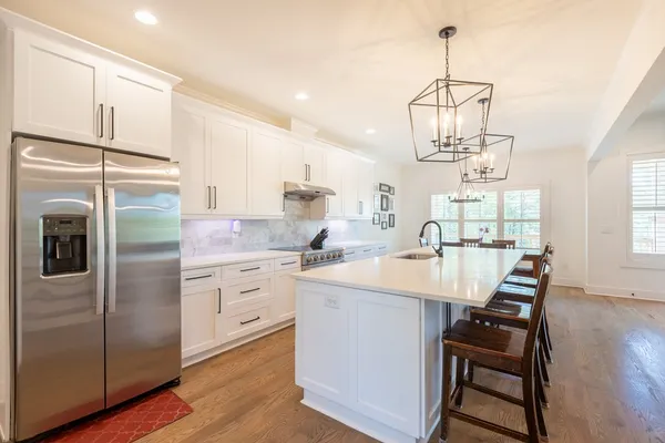 a kitchen with stainless steel appliances a kitchen island hardwood floor sink stove and wooden floor