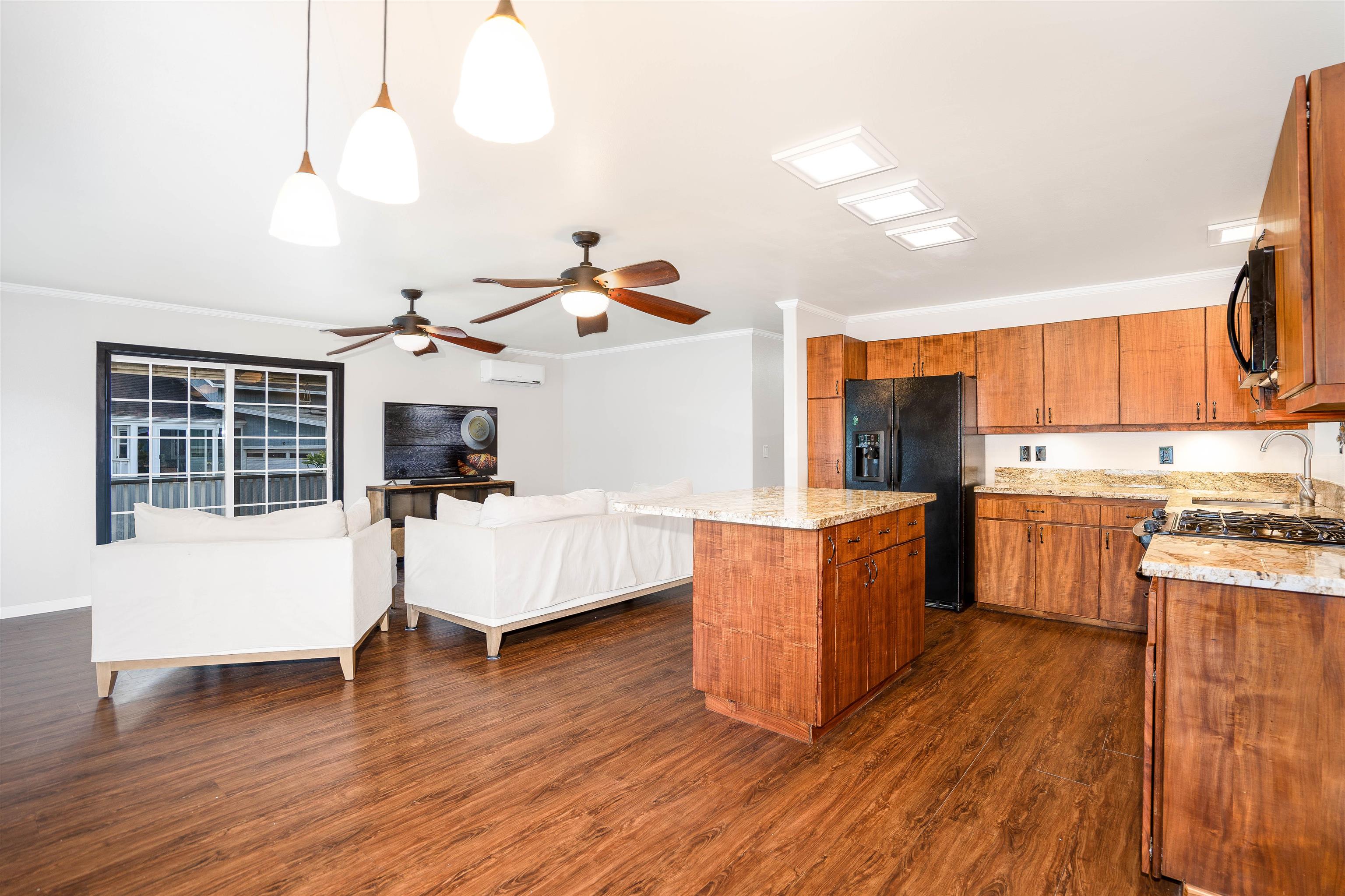 8 Laupapa Place Haiku, HI 96708 - Photo 3 of 30 a living room with stainless steel appliances kitchen island granite countertop wooden floors and a view of kitchen