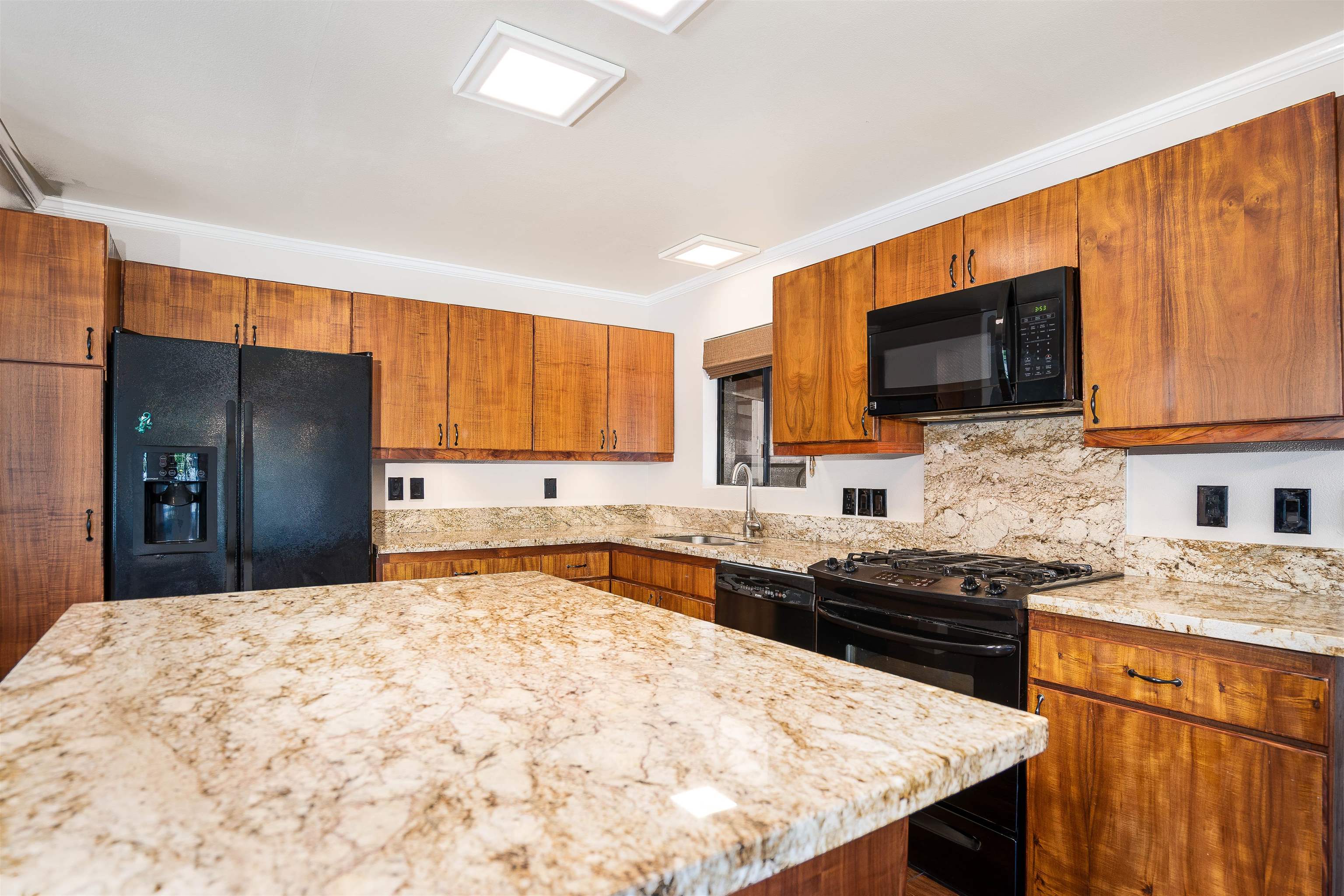 8 Laupapa Place Haiku, HI 96708 - Photo 4 of 30 a kitchen with stainless steel appliances granite countertop a stove top oven a sink dishwasher and a refrigerator with wooden floor