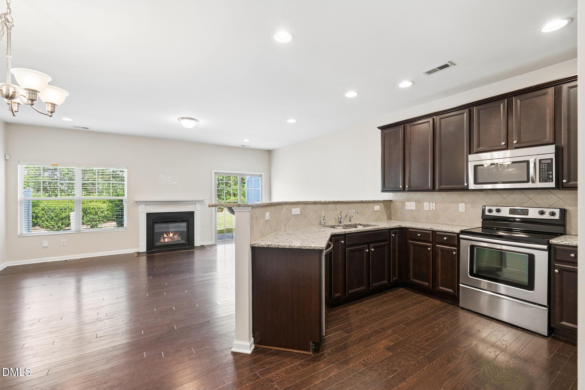 110 Marsena Lane Cary, NC 27513 - Photo 12 of 46 a kitchen with wooden cabinets and stainless steel appliances