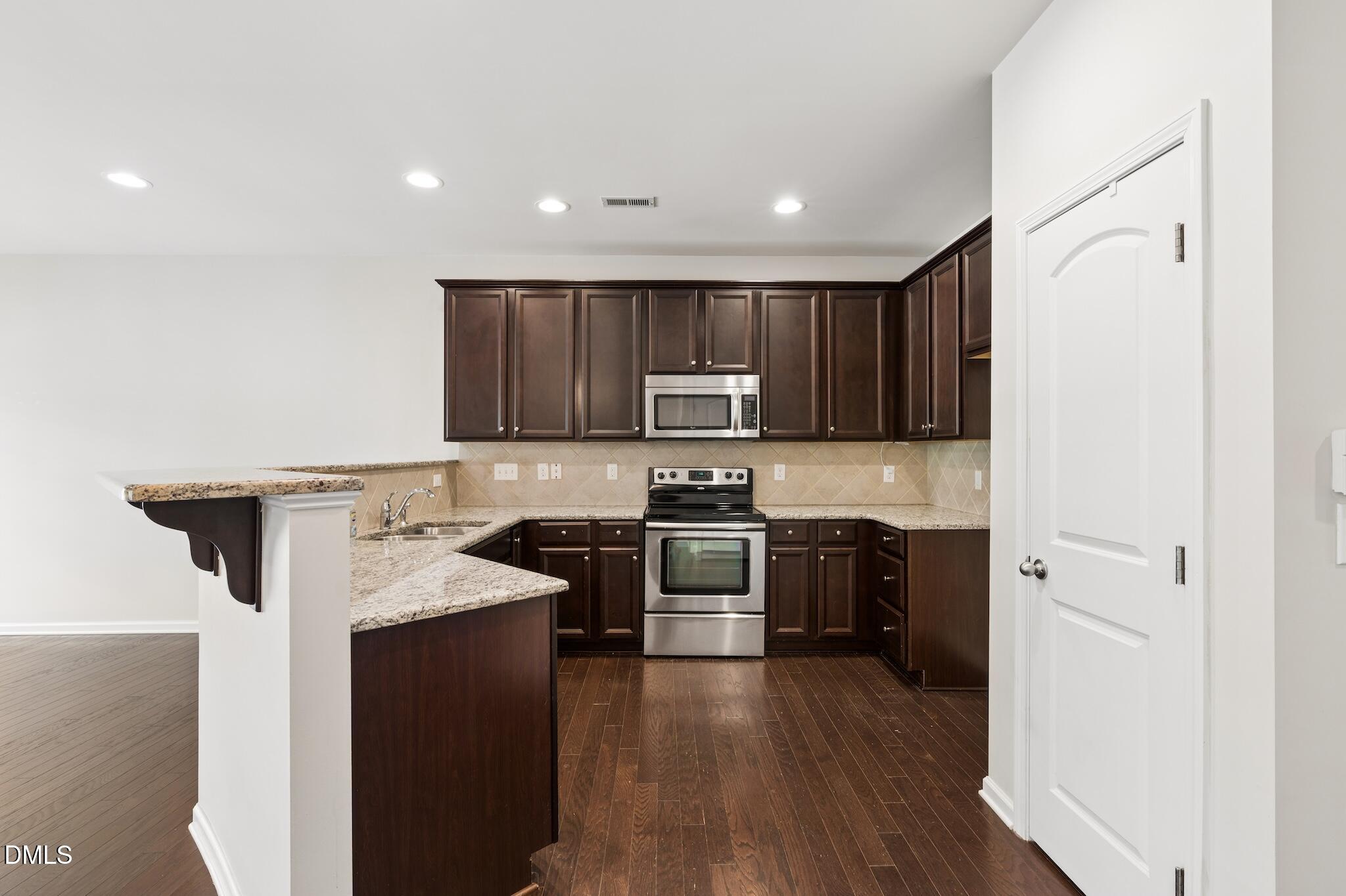 110 Marsena Lane Cary, NC 27513 - Photo 13 of 46 a kitchen with a sink a stove top oven and refrigerator