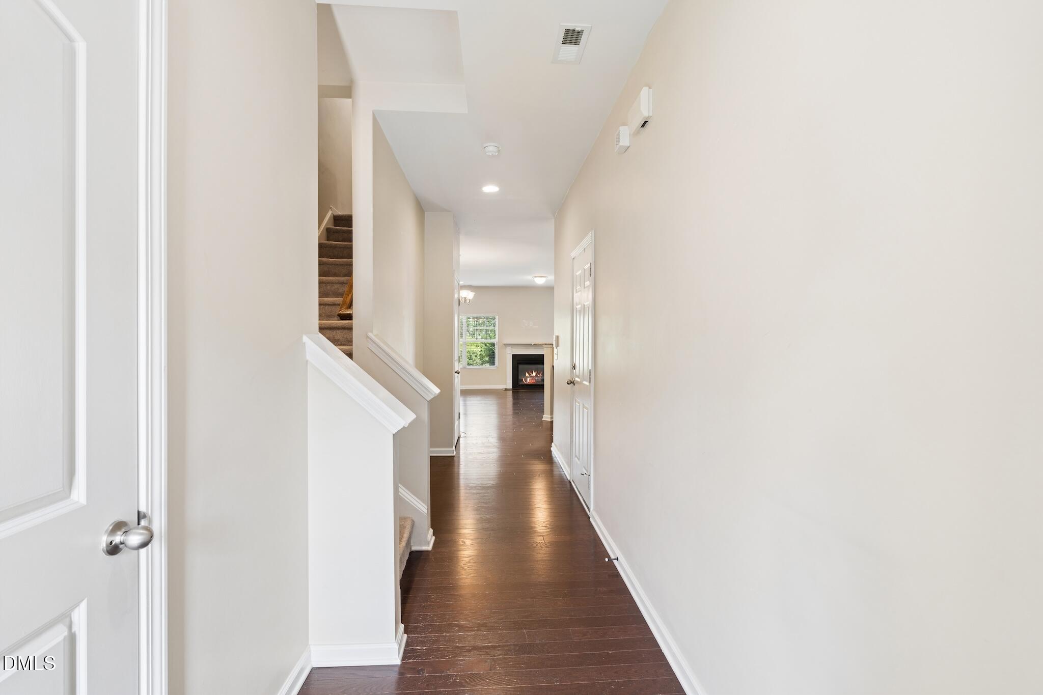 110 Marsena Lane Cary, NC 27513 - Photo 9 of 46 a view of a hallway with wooden floor and staircase