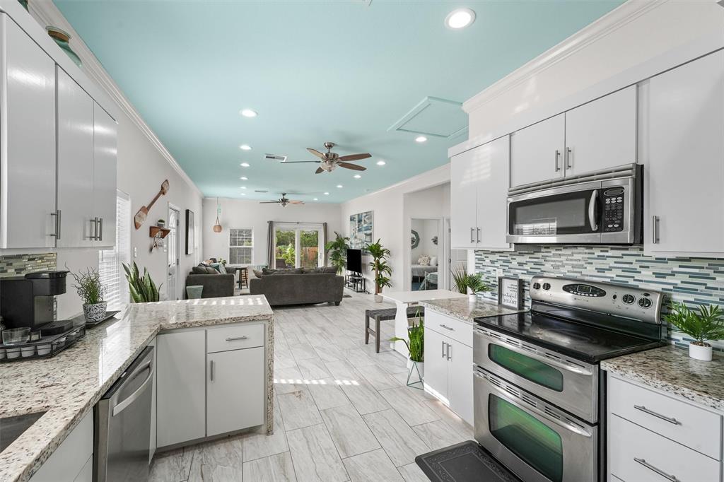 a kitchen with stainless steel appliances granite countertop a sink dishwasher stove and oven with wooden floor