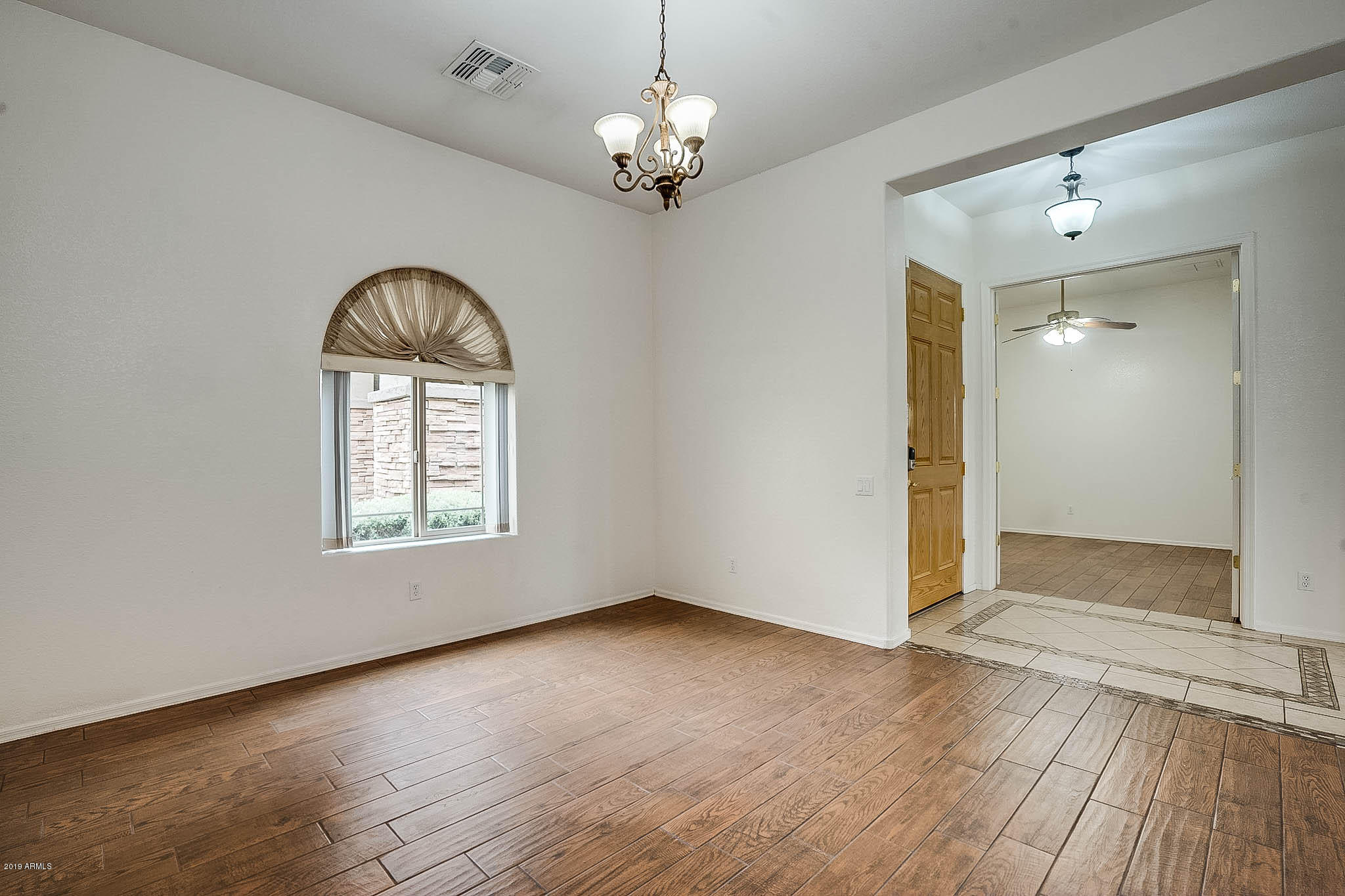 9306 West Rascon Loop Phoenix, AZ 85037 - Photo 3 of 9 wooden floor in an empty room with a window