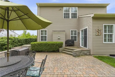 a view of a house with backyard and sitting area