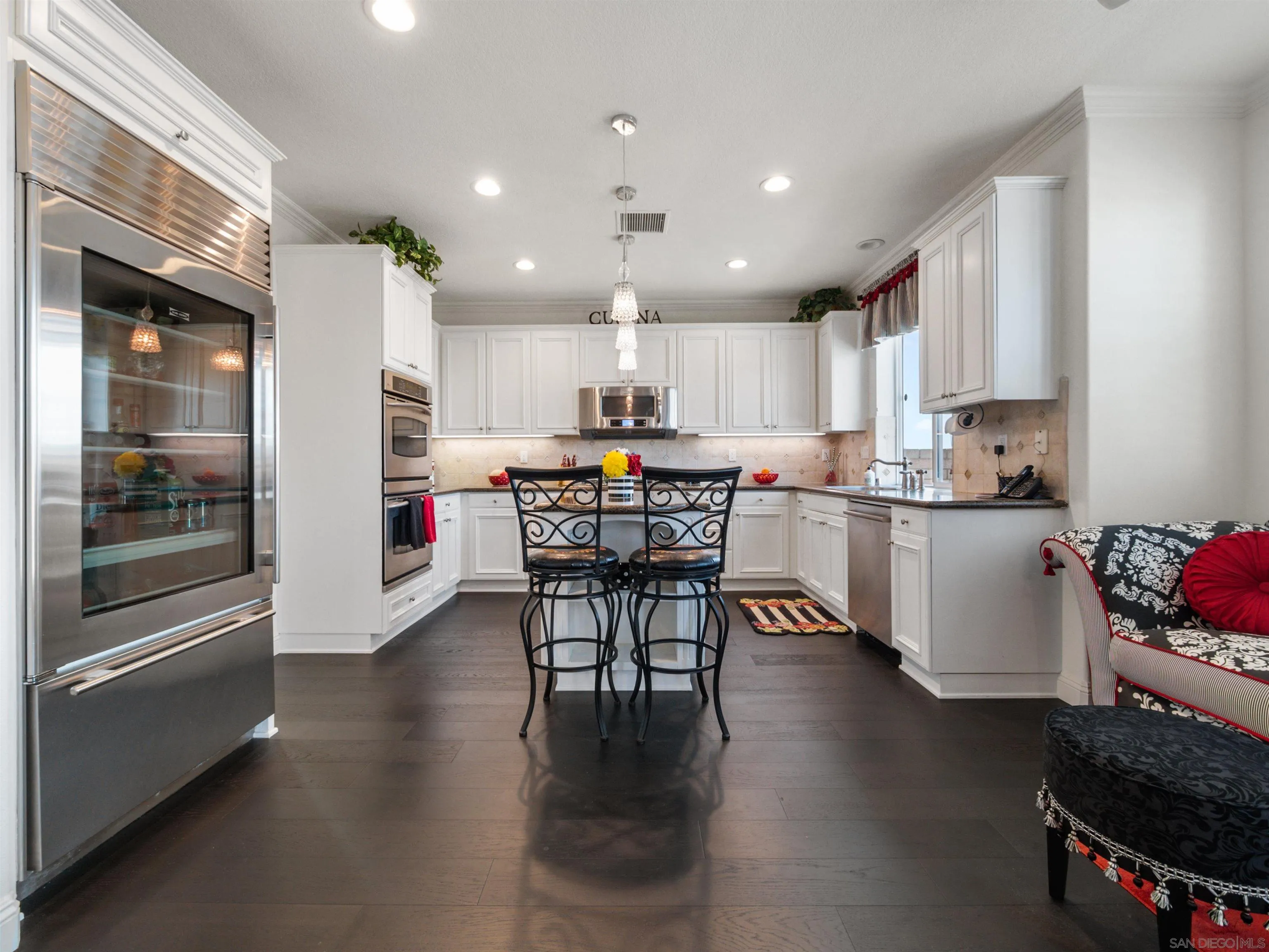 27751 Country Lane Road Laguna Niguel, CA 92677 - Photo 22 of 43 a kitchen with stainless steel appliances granite countertop a stove top oven a sink a dining table and chairs with wooden floor