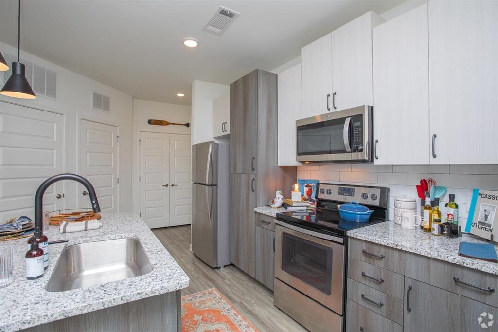 6255 Riverview Road Southeast, Unit B1 Smyrna, GA 30126 - Photo 11 of 17 a kitchen with granite countertop a sink stainless steel appliances and cabinets