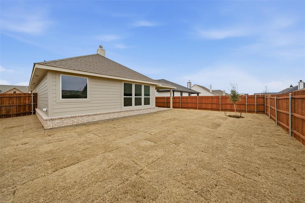 1228 Sabine River Lane Springtown, TX 76082 - Photo 29 of 30 Rear view of house featuring a fenced backyard, a chimney, and a shingled roof