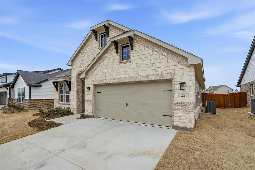 1228 Sabine River Lane Springtown, TX 76082 - Photo 5 of 30 View of front facade with driveway, stone siding, and a garage