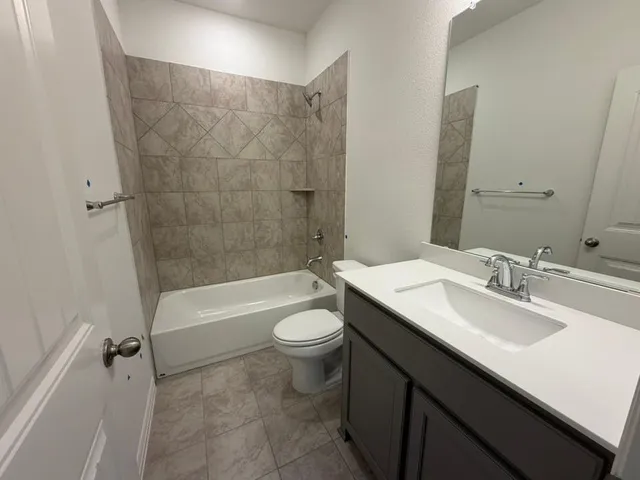 a bathroom with a double vanity sink toilet mirror and bathtub