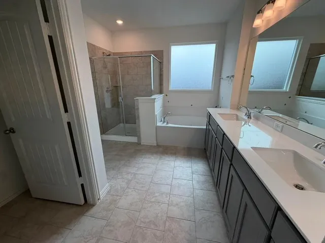 a bathroom with a tub sink and mirror
