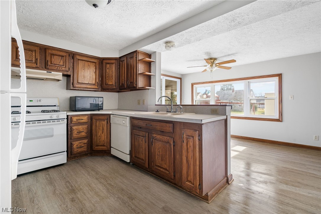 2942 17th Street Northwest Canton, OH 44708 - Photo 10 of 25 Kitchen with white appliances, sink, ceiling fan, and light wood-type flooring