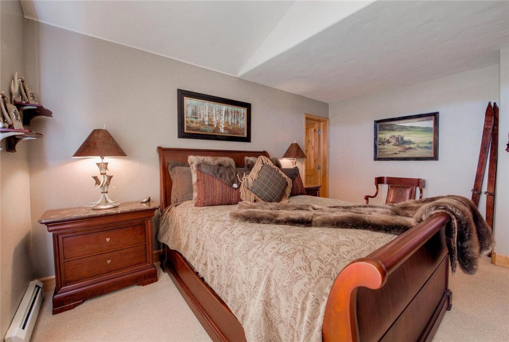 334 D Streamside Lane Frisco, CO 80443 - Photo 19 of 35 a bedroom with a bed and a lamp on dresser