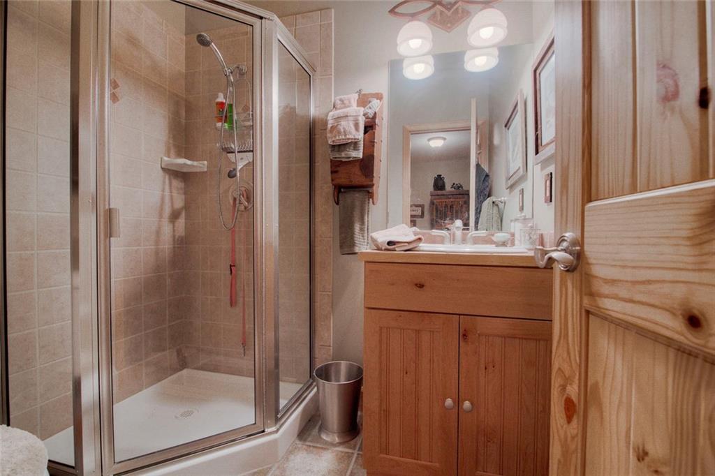 334 D Streamside Lane Frisco, CO 80443 - Photo 33 of 35 a bathroom with a mirror a sink and shower