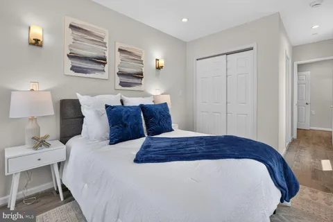 a large bedroom with a bed and wooden floor