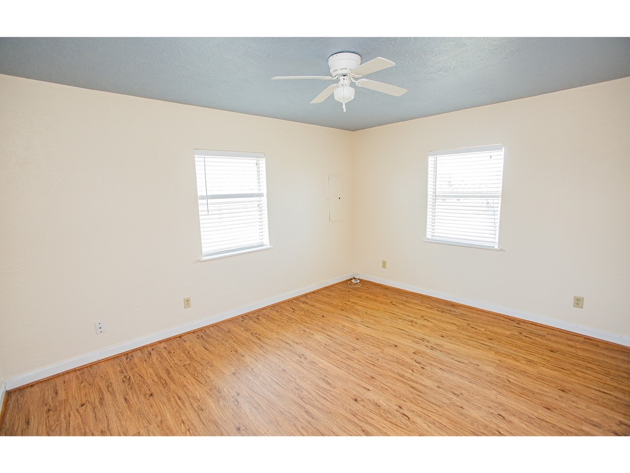 419 Thunder Road Surfside Beach, TX 77541 - Photo 19 of 32 Bright room with two windows, neutral walls, wood flooring, and a ceiling fan.