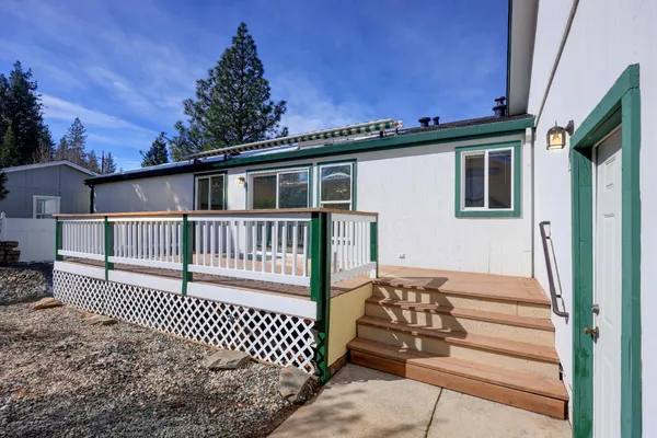 an empty room with a chandelier fan and windows