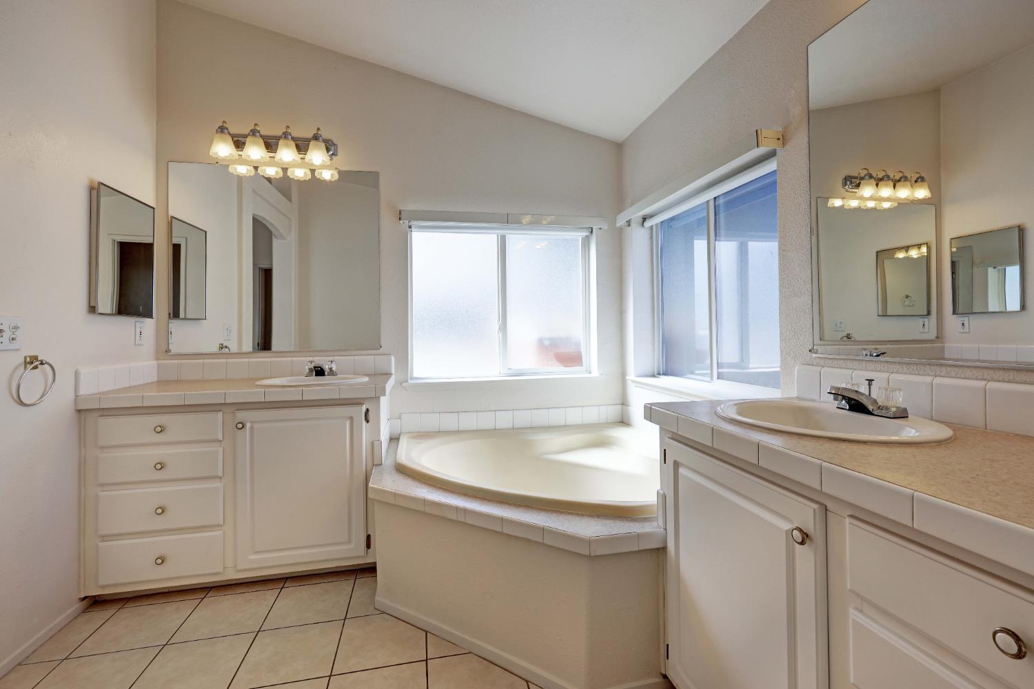 450 Gladycon Road, Unit 83 Colfax, CA 95713 - Photo 42 of 52 a bathroom with a granite countertop sink a large mirror and a bathtub