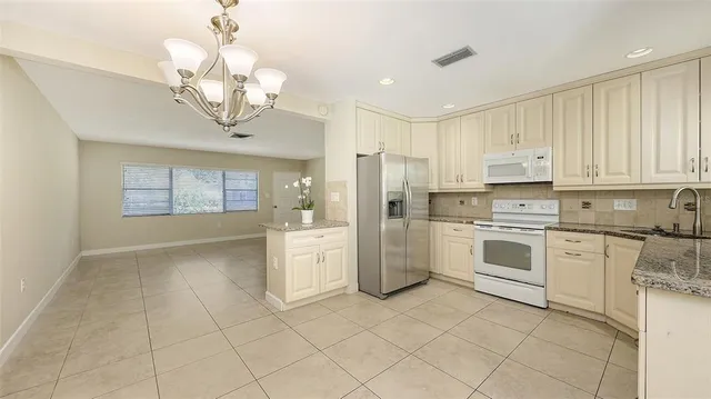 a kitchen with granite countertop white cabinets and white appliances