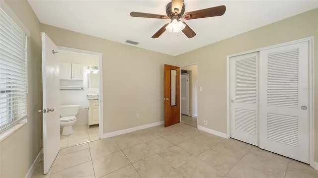 a bathroom with a granite countertop sink a toilet and a mirror