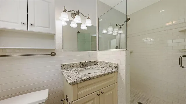 a bathroom with a granite countertop bathtub shower sink and mirror