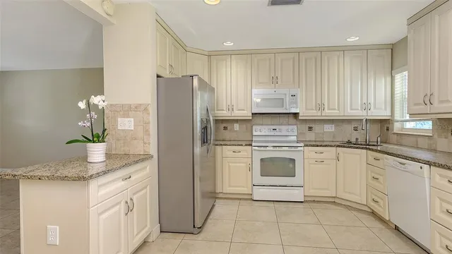 a large white kitchen with a stove a sink dishwasher and a refrigerator