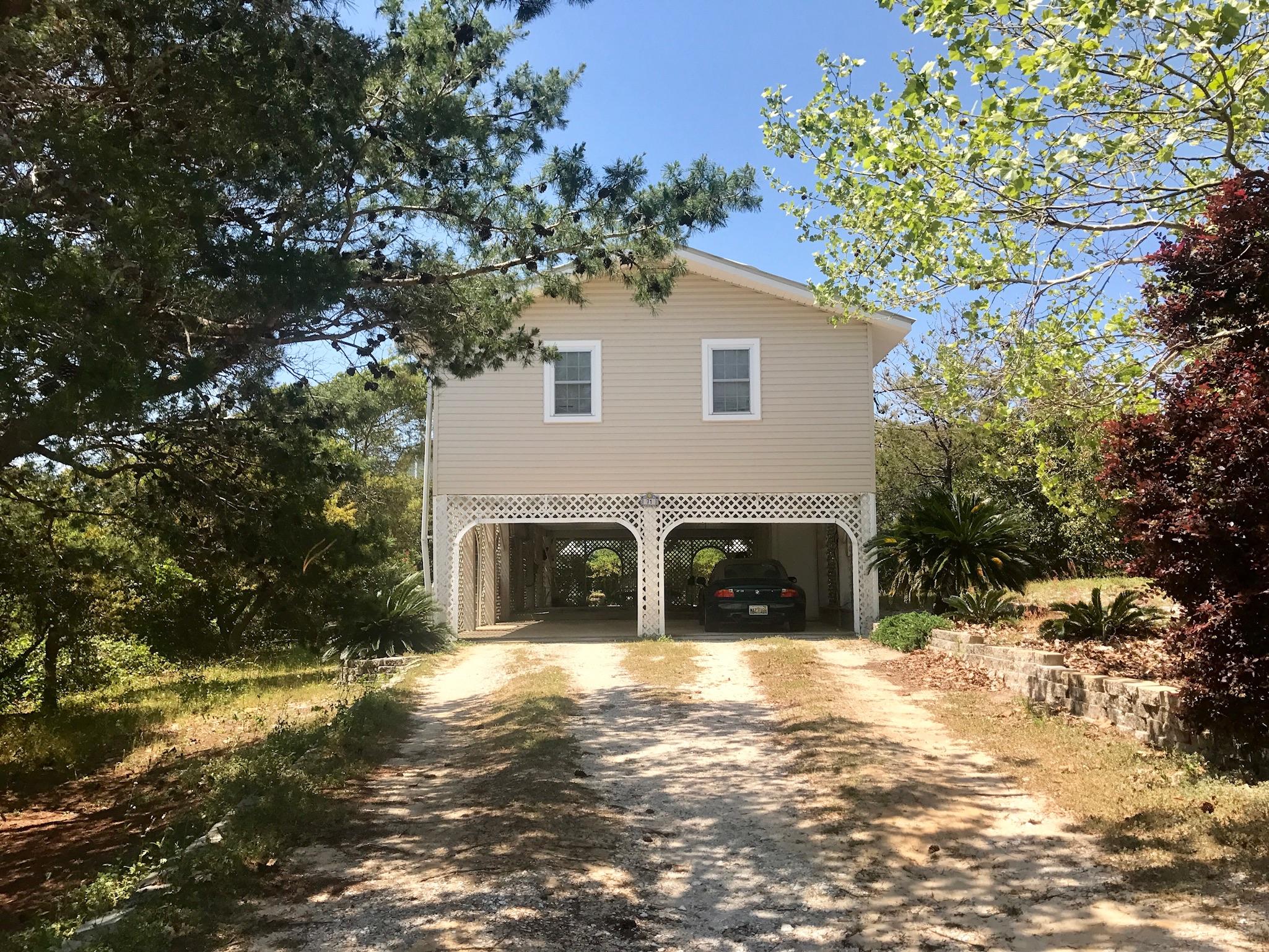 71 Baird Road Santa Rosa Beach, FL 32459 - Photo 1 of 16 a view of a white house next to a yard with large trees
