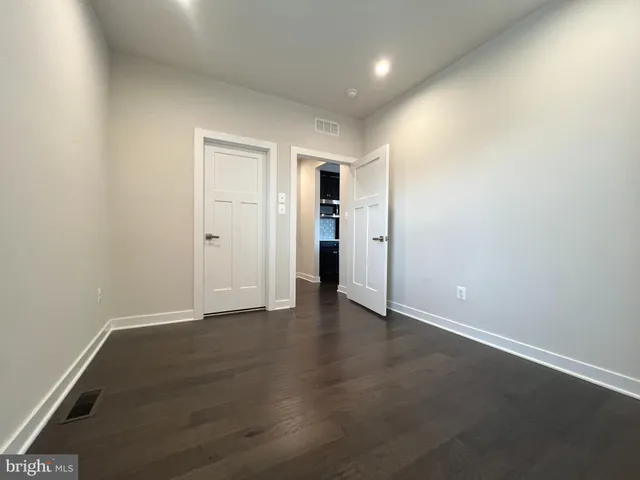an empty room with wooden floor and closet