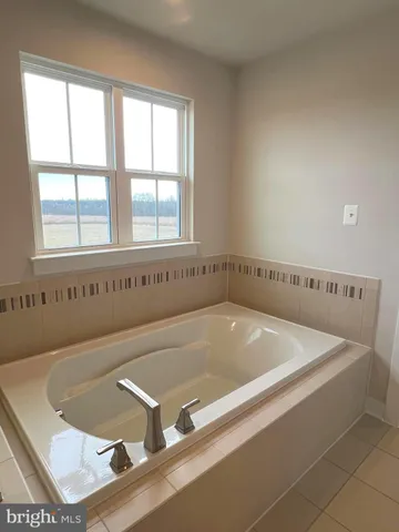 a bath tub sitting in a bathroom next to a window