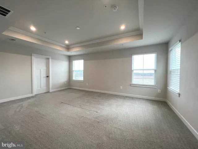 an empty room with windows and closet