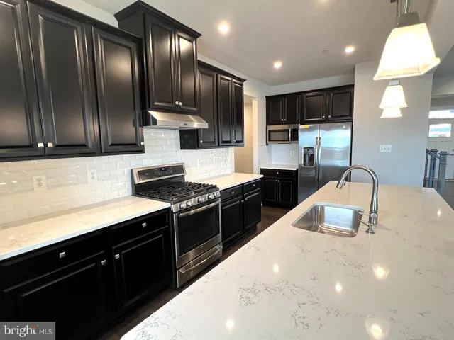 a kitchen with stainless steel appliances granite countertop wooden cabinets a stove top oven a sink and dishwasher