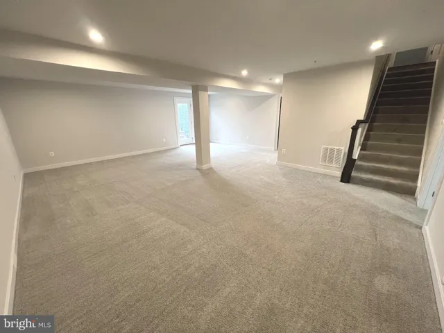 an empty room with a ceiling fan and windows