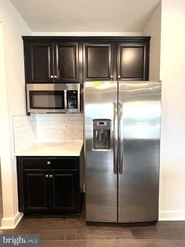 a kitchen with kitchen island a counter and a refrigerator