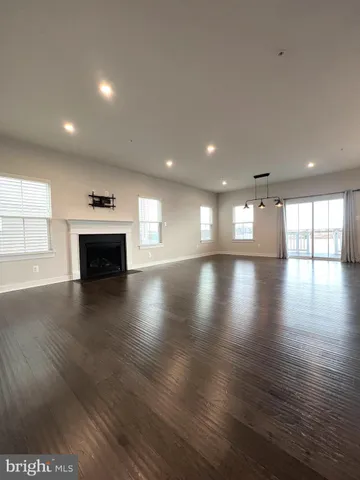 an empty room with wooden floor and a fireplace