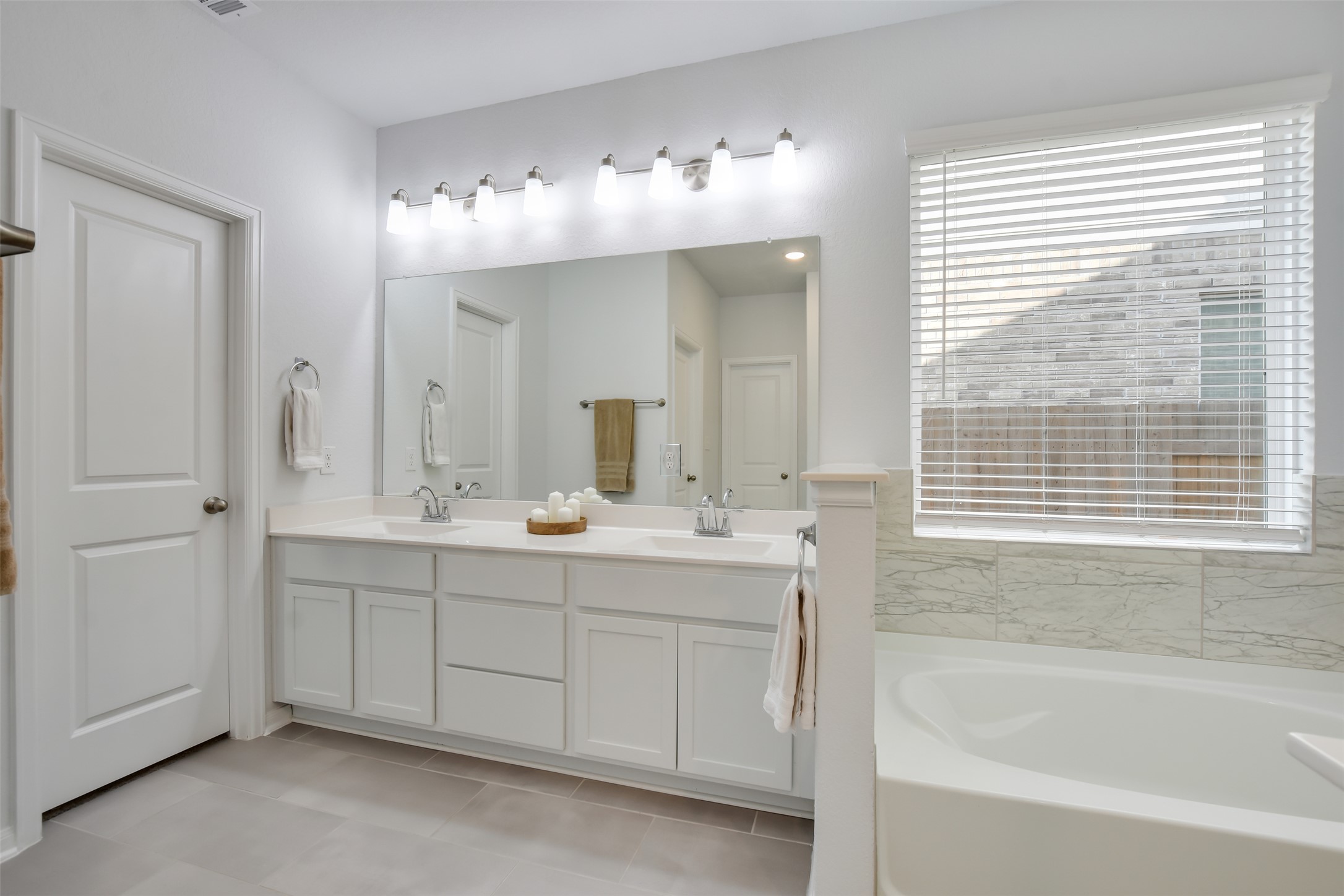 605 Oleander Loop Buda, TX 78610 - Photo 18 of 32 a bathroom with a tub sink and mirror